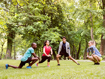 Sportgruppe beim Training im Park – Kniebeugen im Kreis