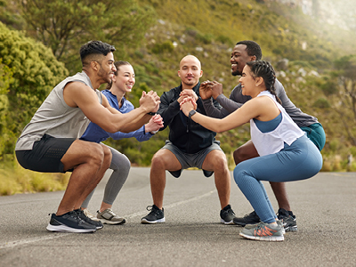 Gruppe trainiert gemeinsam im Freien mit Trainerin